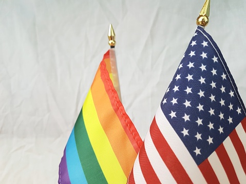 The US flag and behind it, the rainbow flag of the LGBT+ movement. This photo was taken horizontally.