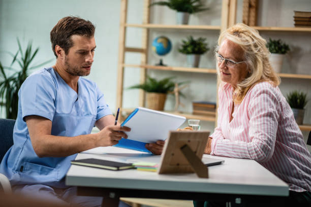 istock General practitioner and mature woman going through medical documents together. 1153112742
