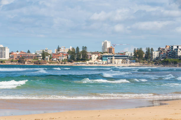 istock Beautiful beach with mild waves and cityscape on the background 1153114972