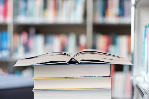 istock Open book on a stack of books in a library. 1153116933