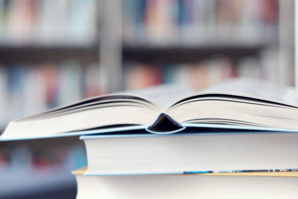 istock Open book on a stack of books in a library. 1153118740