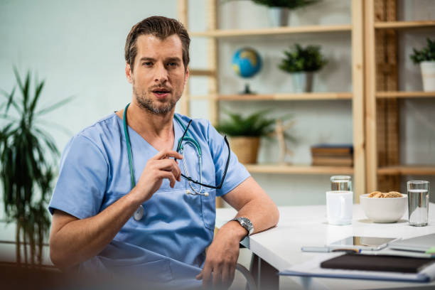 istock Pensive doctor sitting in his office and looking at camera. 1153121003