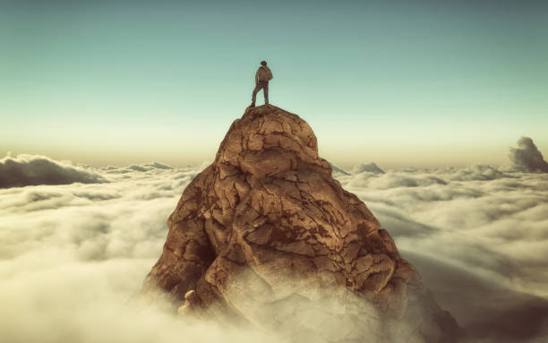 istock Hiker standing on a mountain peak above clouds . This is a 3d illustration 1153147685