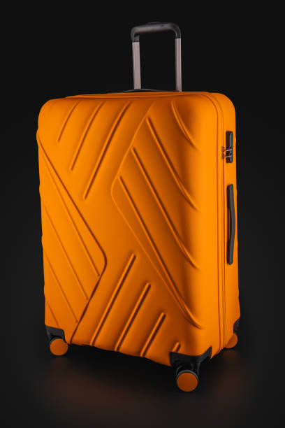 istock Orange suitcase with luggage for flight isolated on black background, clipping path. 1153152000