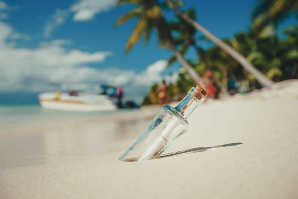 istock Bottle with a message on a tropical island beach 1153152880