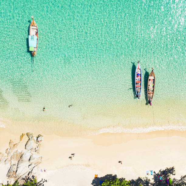 blick von oben, atemberaubender blick aus der luft auf einen wunderschönen tropischen strand mit weißem sand und türkisfarbenem wasser, langen schwanzbooten und liegewiesen, banana-strand, phuket, thailand. - 5412 stock-fotos und bilder