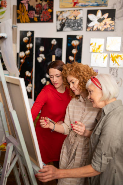 istock Three talented beautiful women painting on canvas together 1153161208