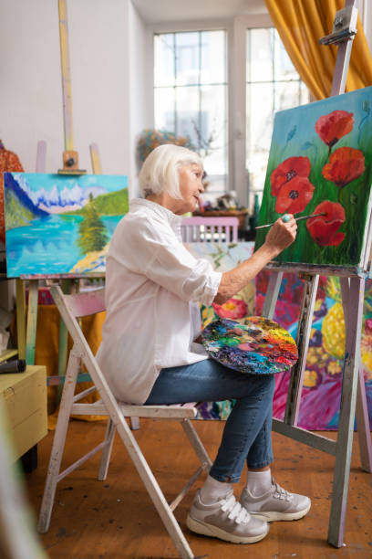 istock Aged woman painting on canvas at the weekend 1153161306