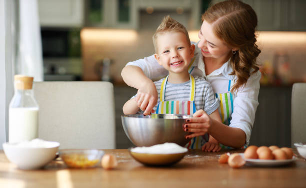 happy family mother and son bake kneading dough in kitchen - 11206 imagens e fotografias de stock