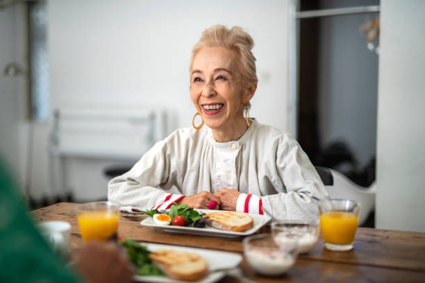 istock Senior Japanese Woman Smiling With Delight During Breakfast 1153165845