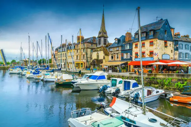 Picturesque waterfront and promenade with street cafes. Amazing cityscape and harbor with boats in Honfleur. Popular travel and leisure destination, Normandy, France, Europe