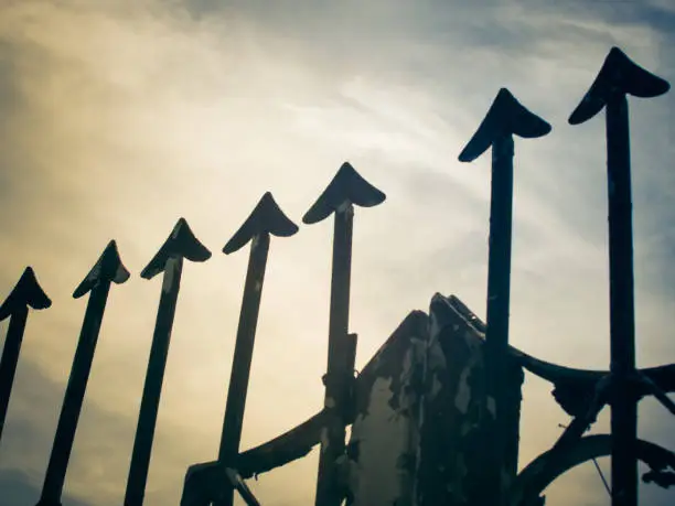 Photo of Rusty metal fence with sharp arrows