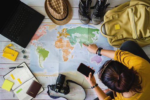 Vacation travel planning concept with map. Overhead view of equipment for travelers. Travel concept background, Young woman pointing to the map India.