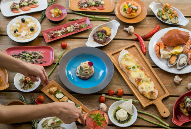 istock Hands serving dishes on table. Many different tasty dishes arrangment 1153172948