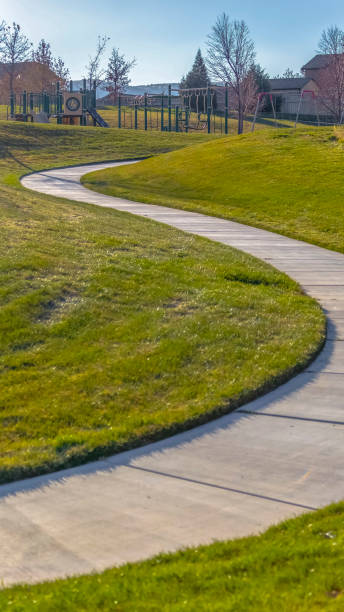 istock Vertical Walkway that winds through a rich grassy field at a park with playground 1153173165