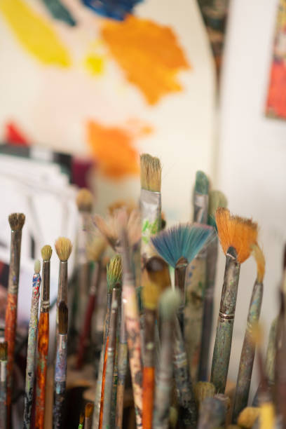 istock Painting brushes standing near the wall in artistic workshop 1153173759