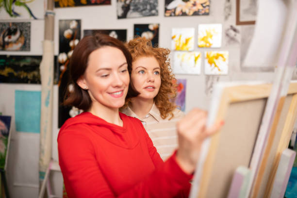 istock Student with red hair standing near drawing tutor 1153173841