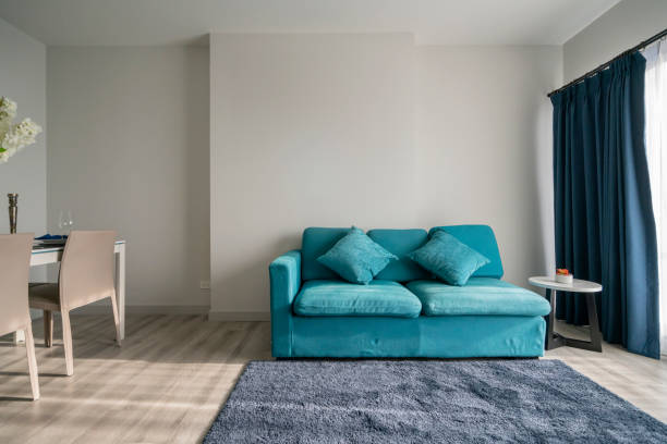 istock minimal apartment interior design with blue sofa and wooden dining table home interior background 1153174127