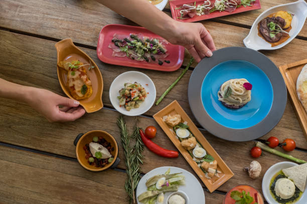 istock Hands serving dishes on table. Many different tasty dishes arrangment 1153174944