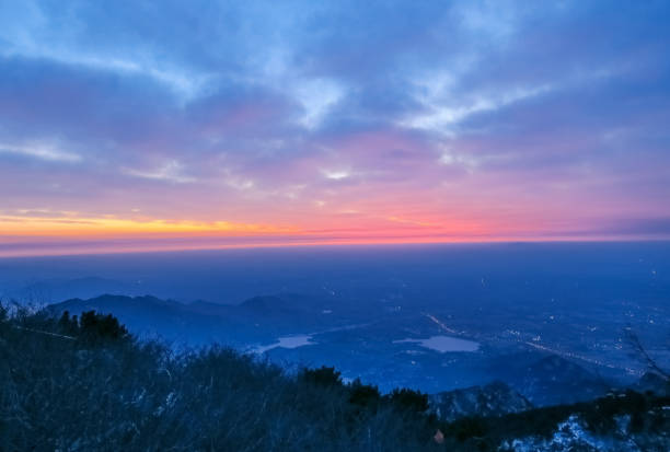 This is the scene taken at the top of mount tai.Mount tai is located in Tai’an City, China.Mount tai is one of the most famous mountains in China.There are many ancient myths and customs about mount tai in China.In ancient China, many emperors had to go to mount tai to offer sacrifices to heaven and earth.Mount tai has a very important historical and cultural status in China.Mount tai sunrise many people want to see the scene, but it is very difficult .Mount tai is also a UNESCO world cultural and natural heritage site. vista del amanecer del monte tai. tai ' an, china-invierno 2017: una vista desde la cima del monte tai. la dirección de las montañas. el resplandor de la mañana del amanecer. nubes sobretensiones, nubes coloridas al amanecer. el amanecer en el horizonte