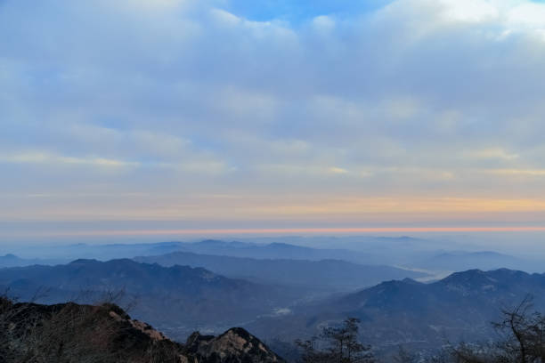 This is the scene taken at the top of mount tai.Mount tai is located in Tai’an City, China.Mount tai is one of the most famous mountains in China.There are many ancient myths and customs about mount tai in China.In ancient China, many emperors had to go to mount tai to offer sacrifices to heaven and earth.Mount tai has a very important historical and cultural status in China.Mount tai sunrise many people want to see the scene, but it is very difficult .Mount tai is also a UNESCO world cultural and natural heritage site. el monte tai encabeza la montaña. tai ' an, china-invierno 2017: vista desde la cima del monte tai, la cima del monte tai. rocas y nieve en los picos. pinos en la cima. las montañas en la distancia se han ido. las nubes lo causaron. las nubes en el cielo