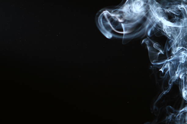 istock pretty flowing glowing blue smoke against heavy black background. 1153182326
