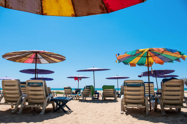 istock Sunbeds and umbrellas on tropical beach with blue sky. 1153187749