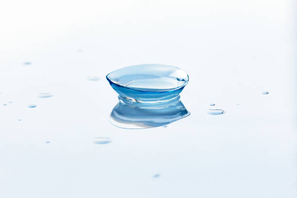 istock Contact lens and water drops on light blue background 1153193258