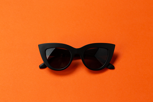 Women's black sunglasses, called cat's eyes. space for text on a bright background