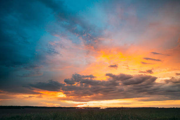 istock Spring Summer Meadow At Evening Sunset Sunrise. Natural Bright Dramatic Sky In Different Colours Above Countryside Meadow Landscape. Agricultural Landscape In May 1153197395