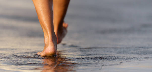 istock Barefoot woman walking in ocean 1153199814