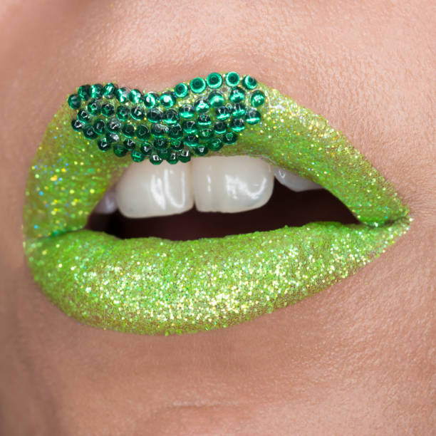 istock Green lips with sparkles covered with gemstones. Beautiful green lipstick on her lips, white teeth open mouth. Lip art 1153203756
