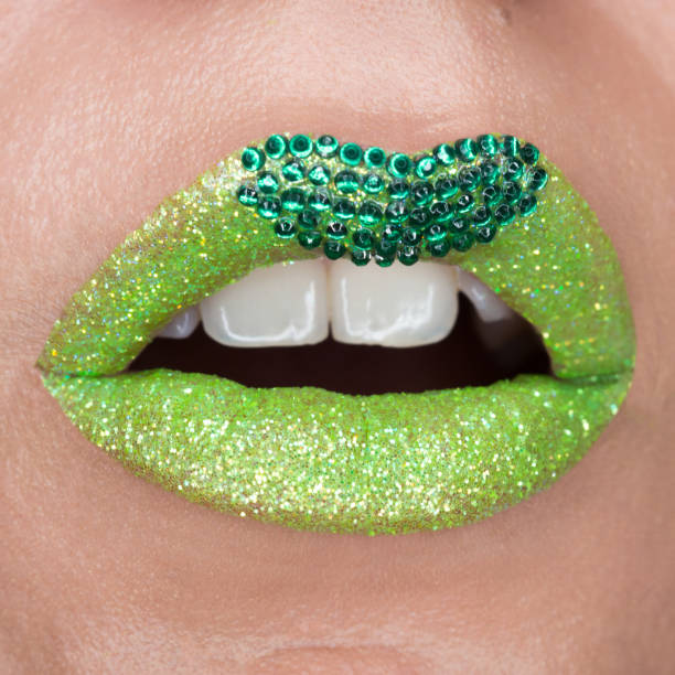 istock Green lips with sparkles covered with gemstones. Beautiful green lipstick on her lips, white teeth open mouth. Lip art 1153203869