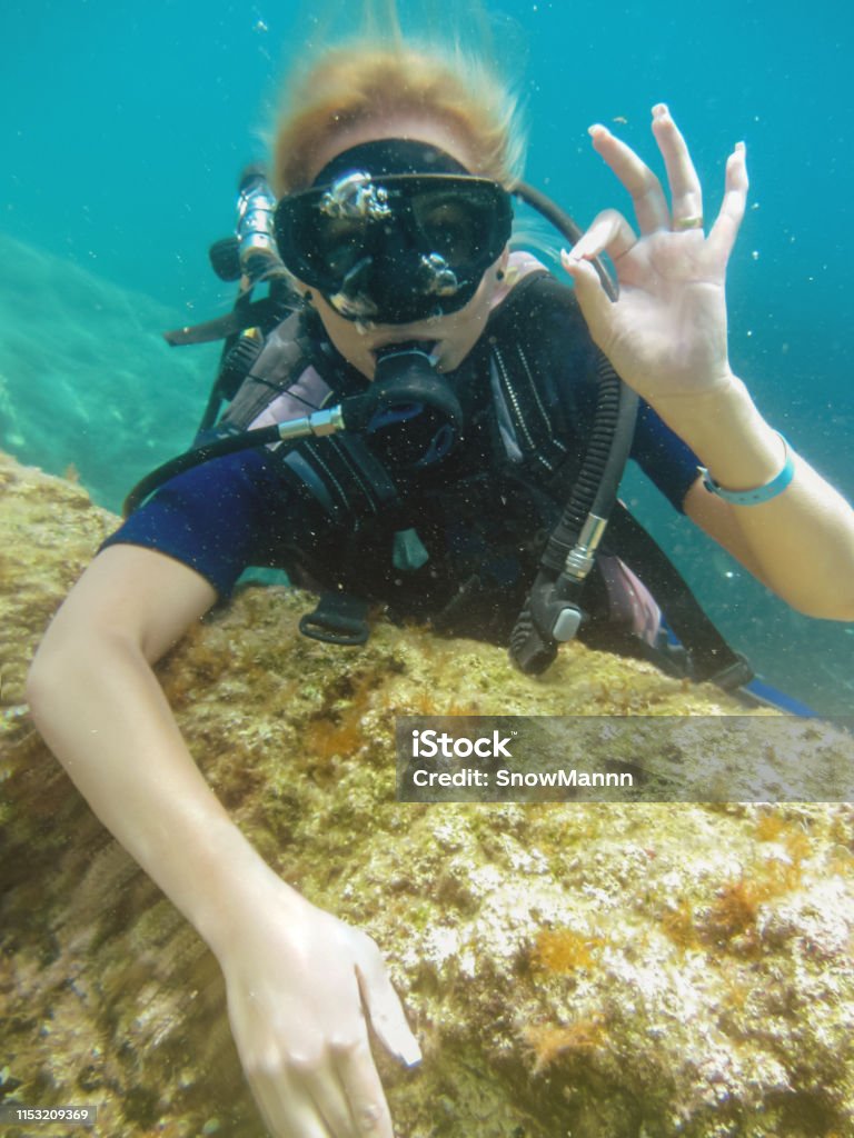 Young caucasian women dressed in a diving suit  having fun underwater , Summervacation and honeymoon . Underwater Diving Stock Photo