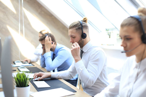 istock Portrait of call center worker accompanied by his team. Smiling customer support operator at work. 1153209665