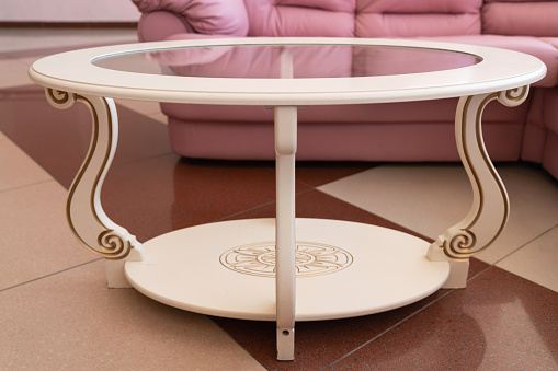 coffee table with white wooden legs and glass top. interior design