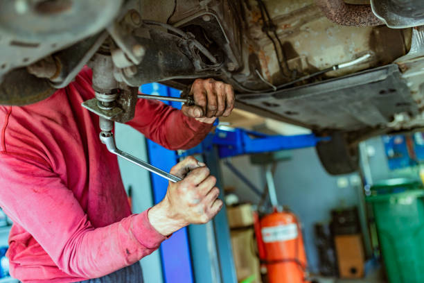 istock Mechanic repairing a lifted car 1153214140