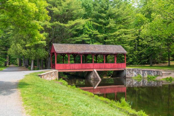 Red covered bridge with trees stock photo