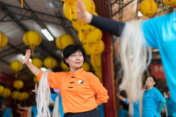 Happy senior woman practicing Tai Chi in a group