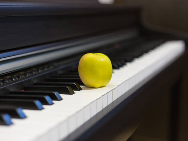 Apple on the classic electrical piano keyboard Apple on the classic electrical piano keyboard apple keyboard stock pictures, royalty-free photos & images