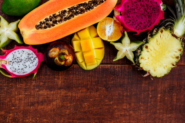 istock Tropical fruits on wooden background 1153222664
