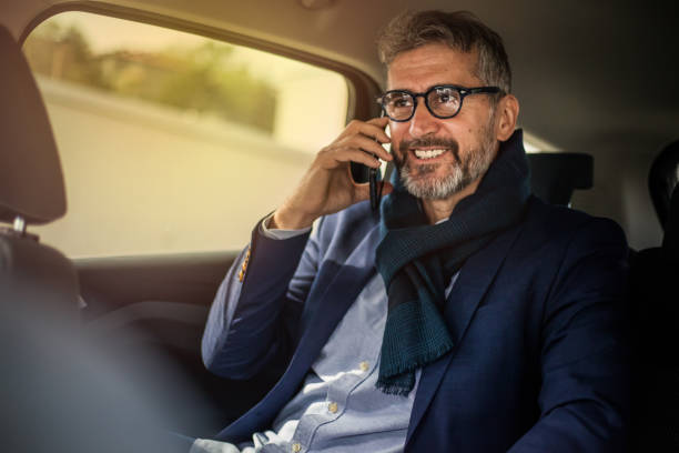 istock Businessman using mobile phone in car 1153224709