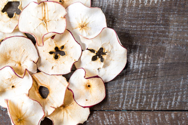 istock Dried apple chips over old wood table with copy space. 1153227129