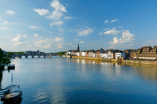 Maas River promenade with historic residential buildings along the river