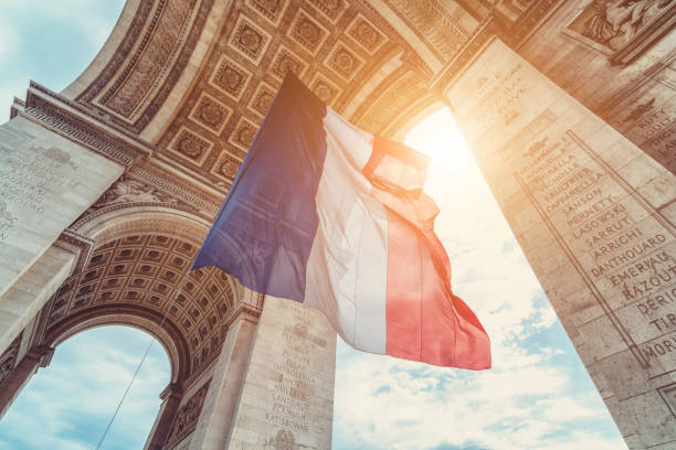 french flag at arc de triomphe on 14th of july french flag at arc de triomphe during bastille day triumphal arch photos stock pictures, royalty-free photos & images