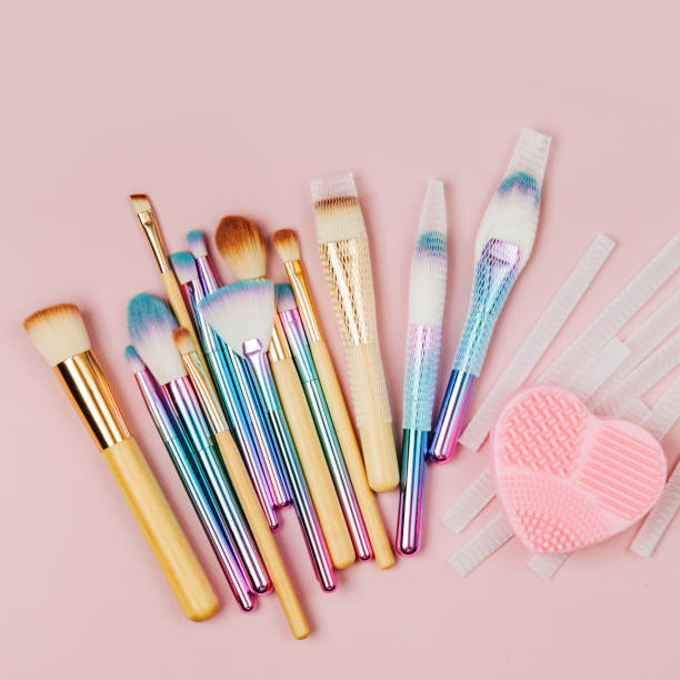 istock Various makeup brushes with Brush Cleansing Pad and brush guard on a pastel pink background. Flat lay, top view 1153229785