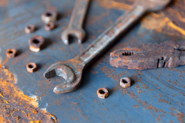 istock Old rusty wrench over battered metal table rough style. Wrenches top view for construction, industrial, electrician concept design 1153230303