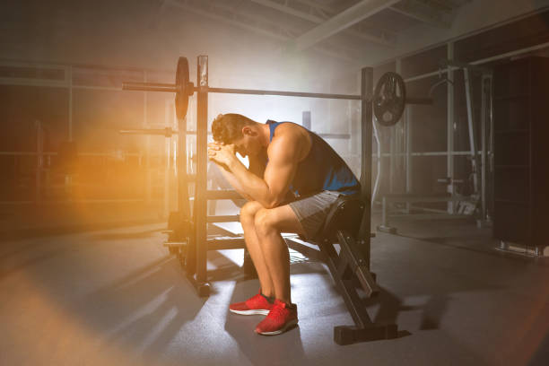 istock The man sit on a bench in the gym on the bright light background 1153233659