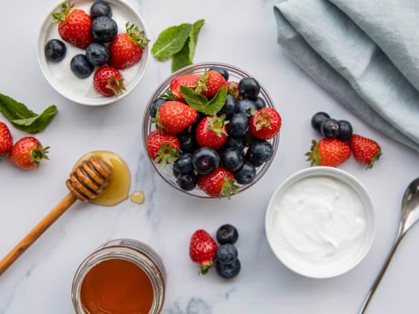 yoghurt with strawberries, blueberries and honey yoghurt with strawberries, blueberries and honey Greek Yogurt with Berries and Honey stock pictures, royalty-free photos & images
