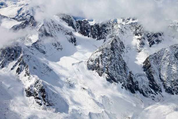 вид с высокой точки на заснеженные горные кулуары и скалы - kazakhstan glacier snow mountain view стоковые фото и изображения